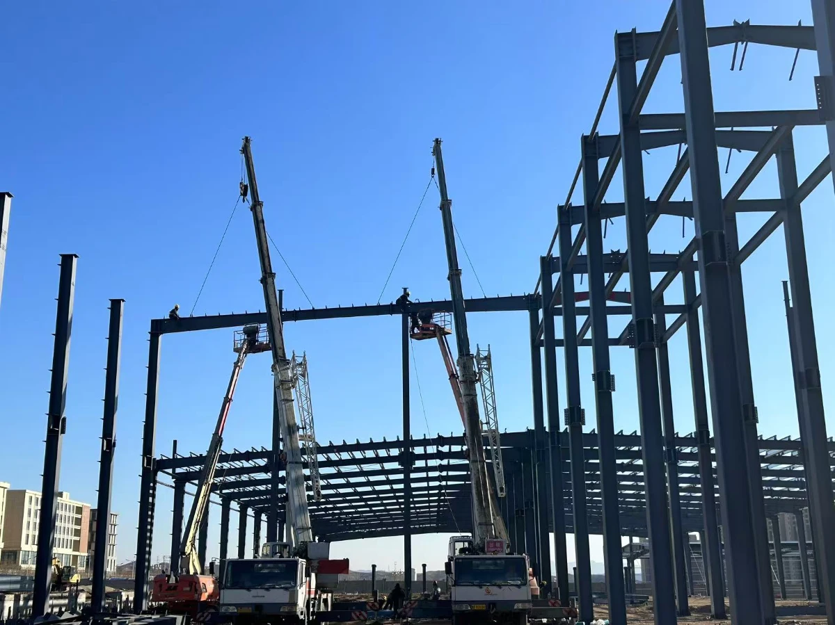 Cranes raising a prefabricated steel structure frame during fast on-site erection