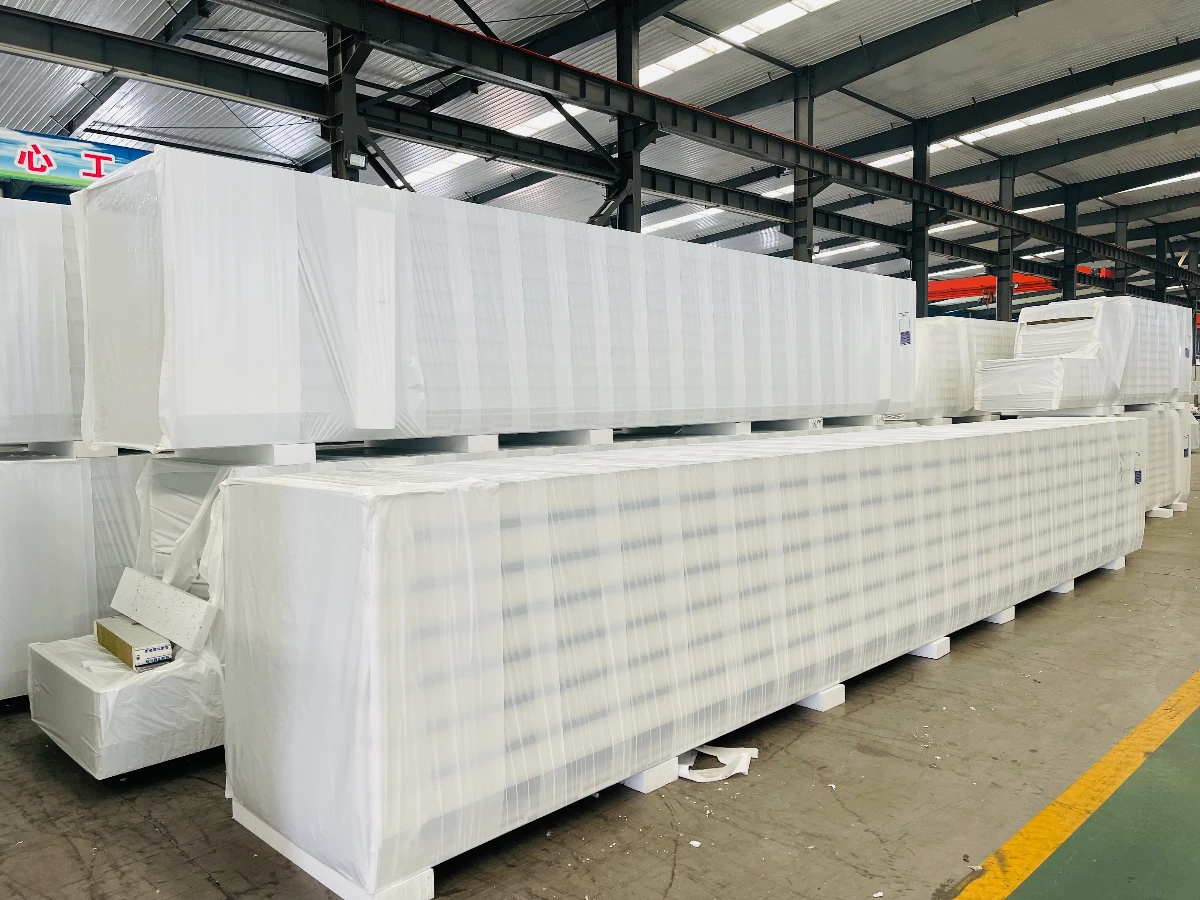 Steel structure panels shrink-wrapped with edge protection on timber bases, staged in the VIKKINS workshop before container loading