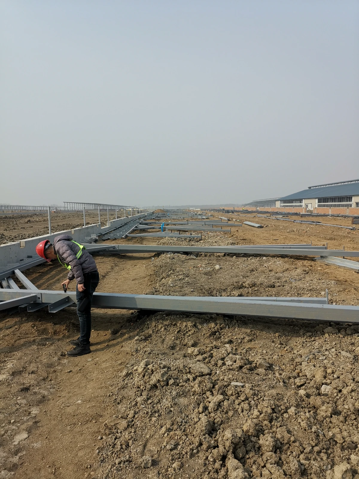 VIKKINS engineer inspecting steel column and frame connections on a steel building construction site