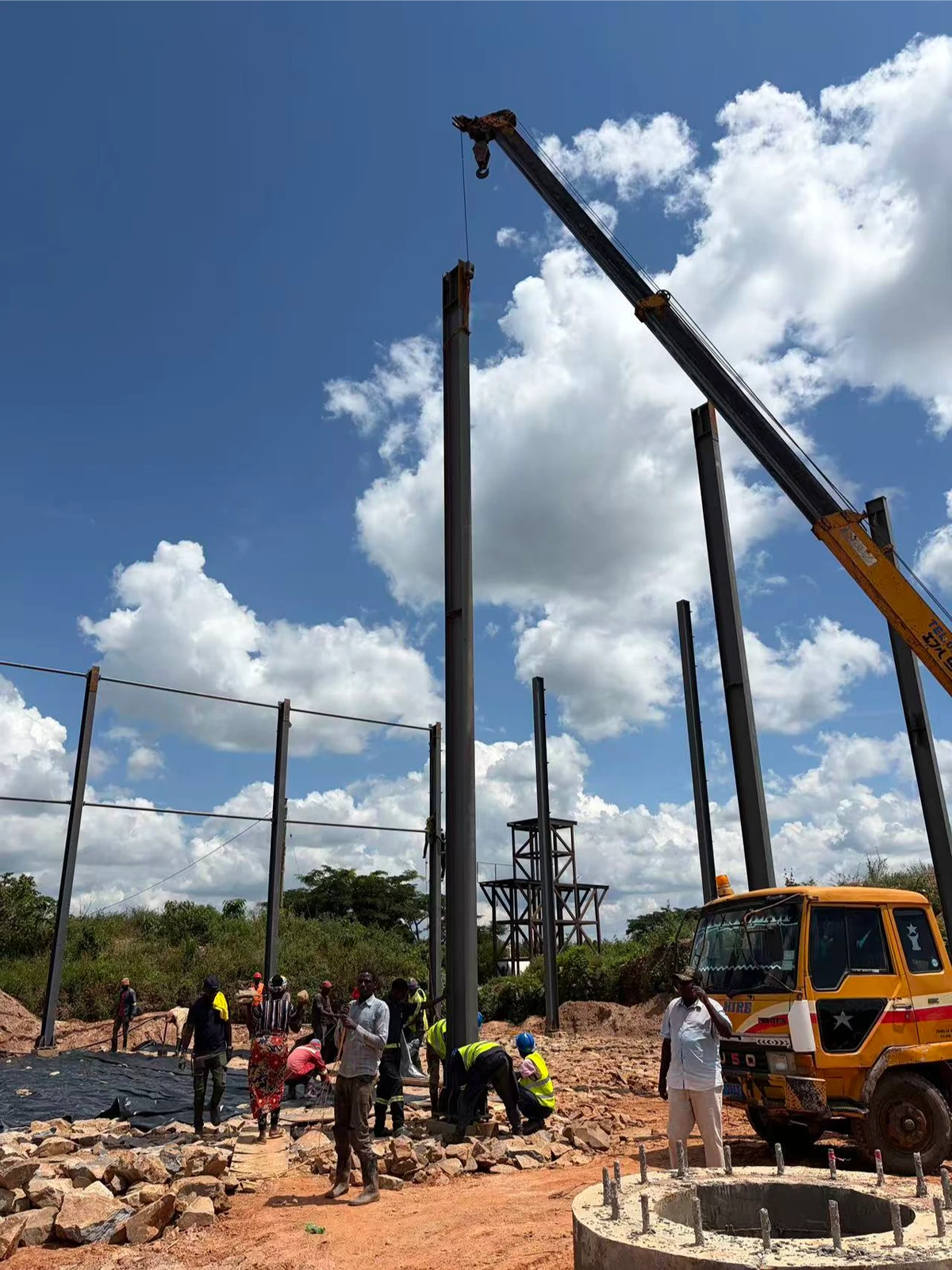 Crane lifting precision fabricated steel frame column at Uganda construction site