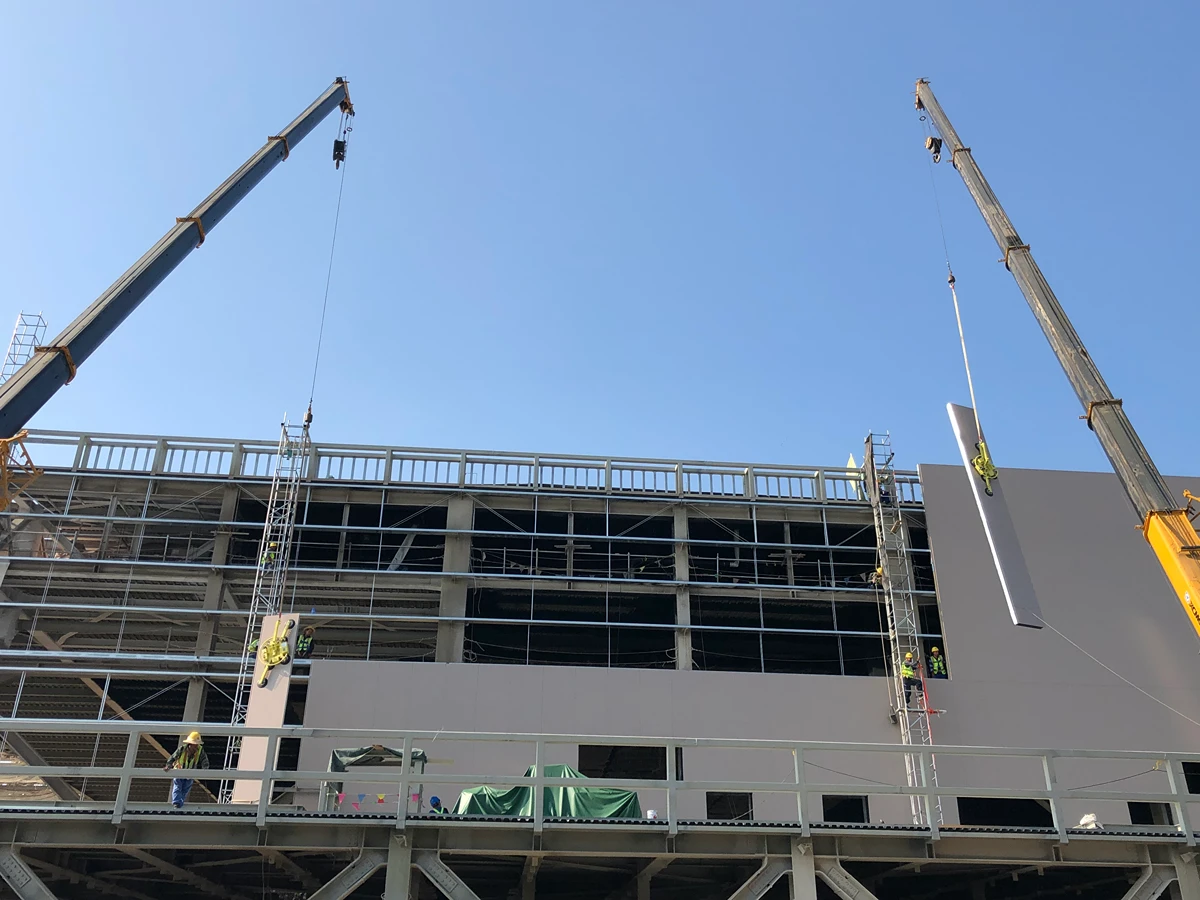 Industrial steel structures: large-span steel building with cranes lifting cladding panels on a Vikkins project